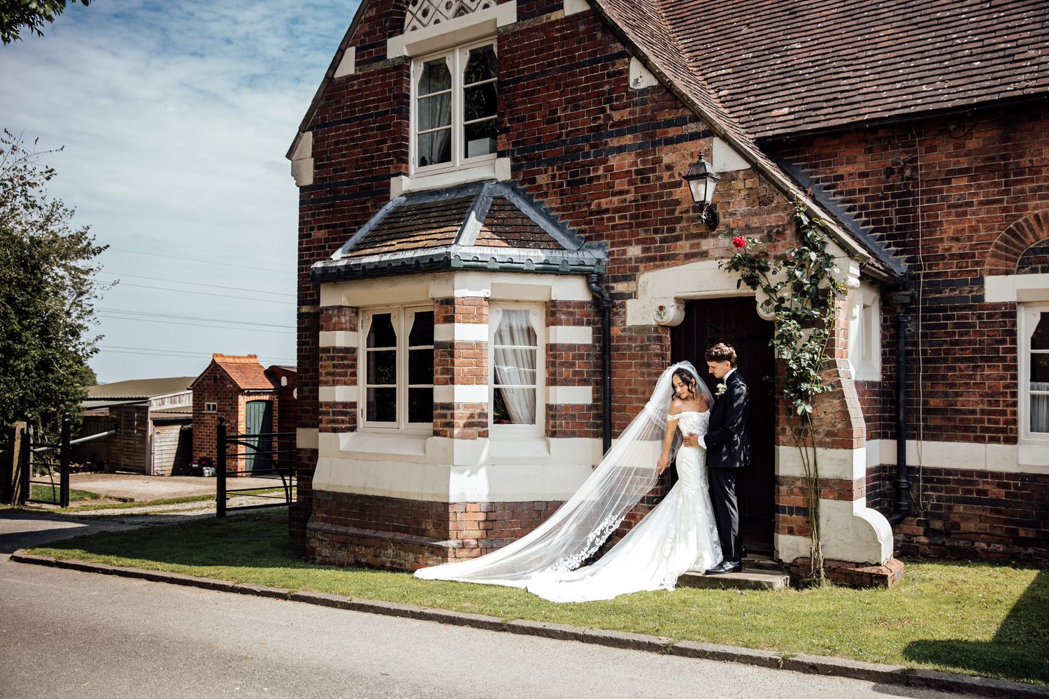 Wedding party poses outside brick church building with classic architecture.