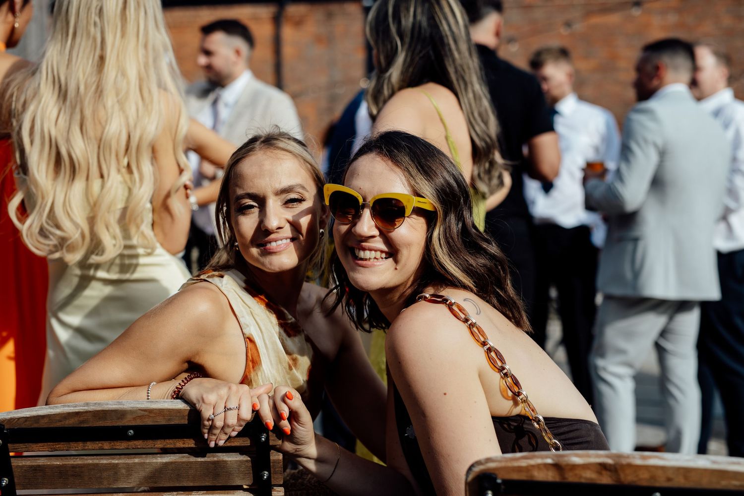 Wedding guests share joyful moments during an outdoor reception celebration.