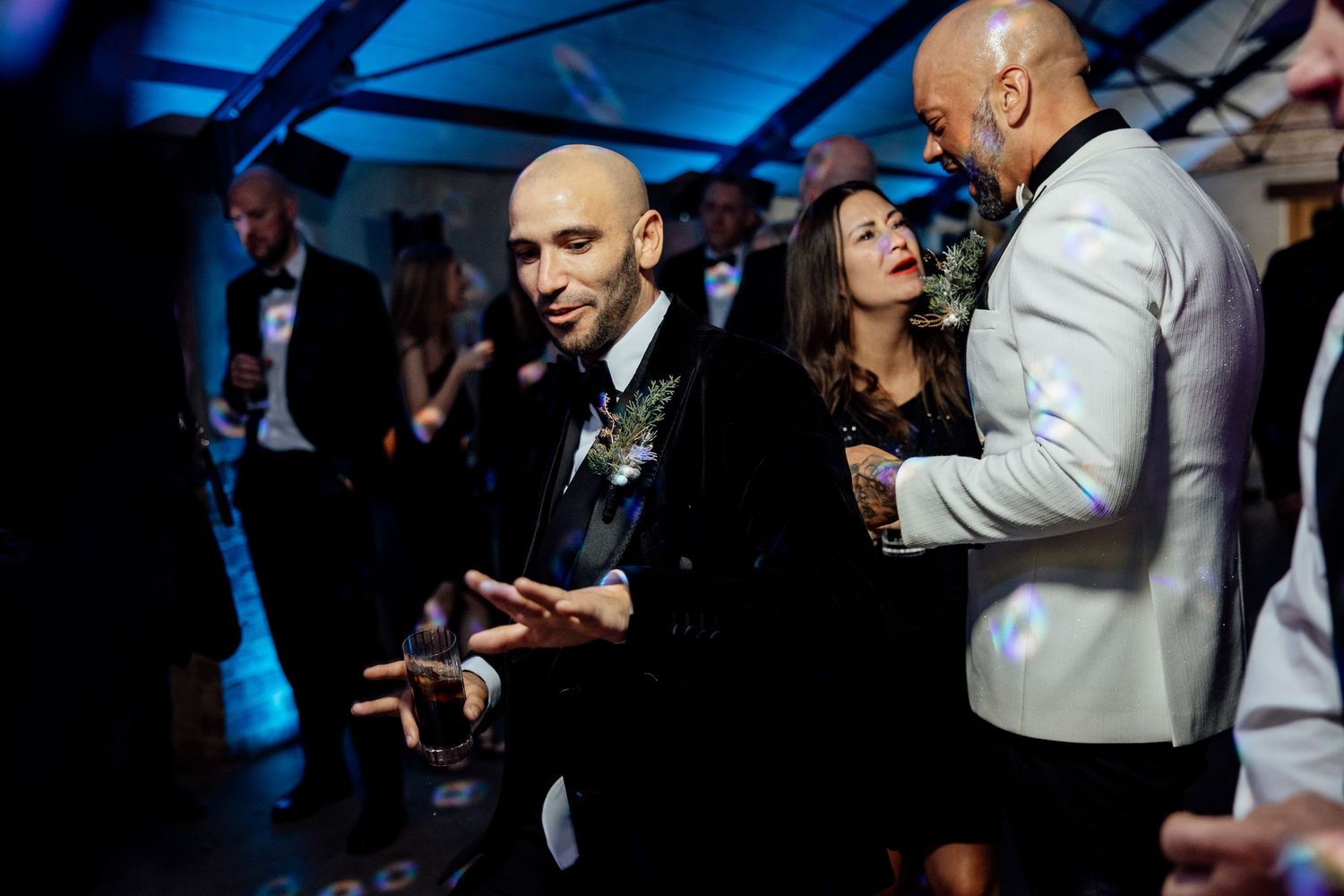 Wedding band performing under blue stage lighting in an intimate venue setting.