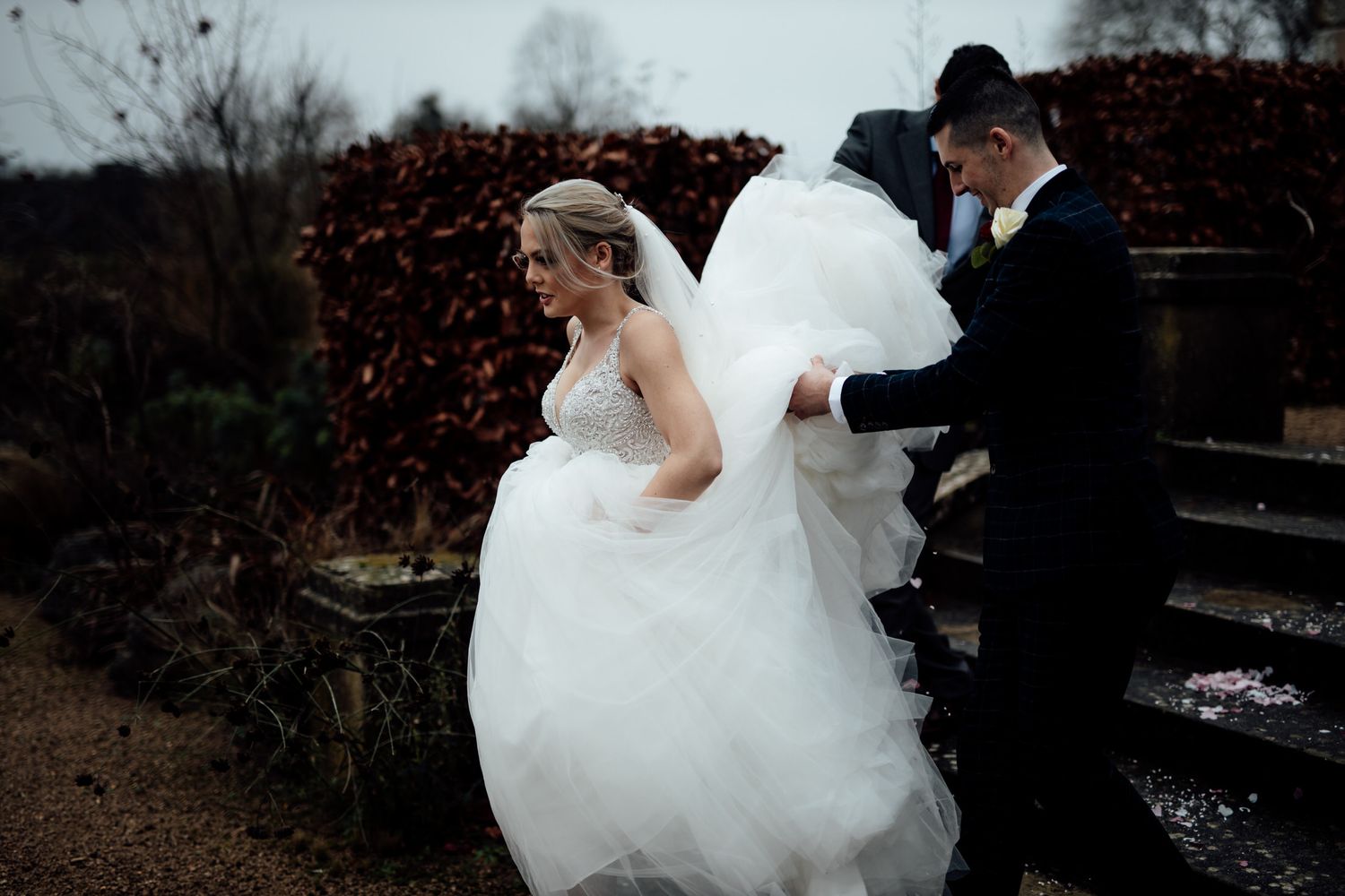 A flowing white wedding dress swirls gracefully during an outdoor photo session at dusk.