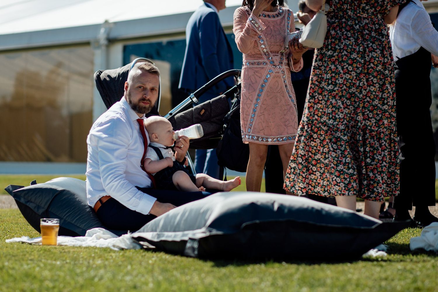 Wedding guests relaxing on blankets during outdoor reception.