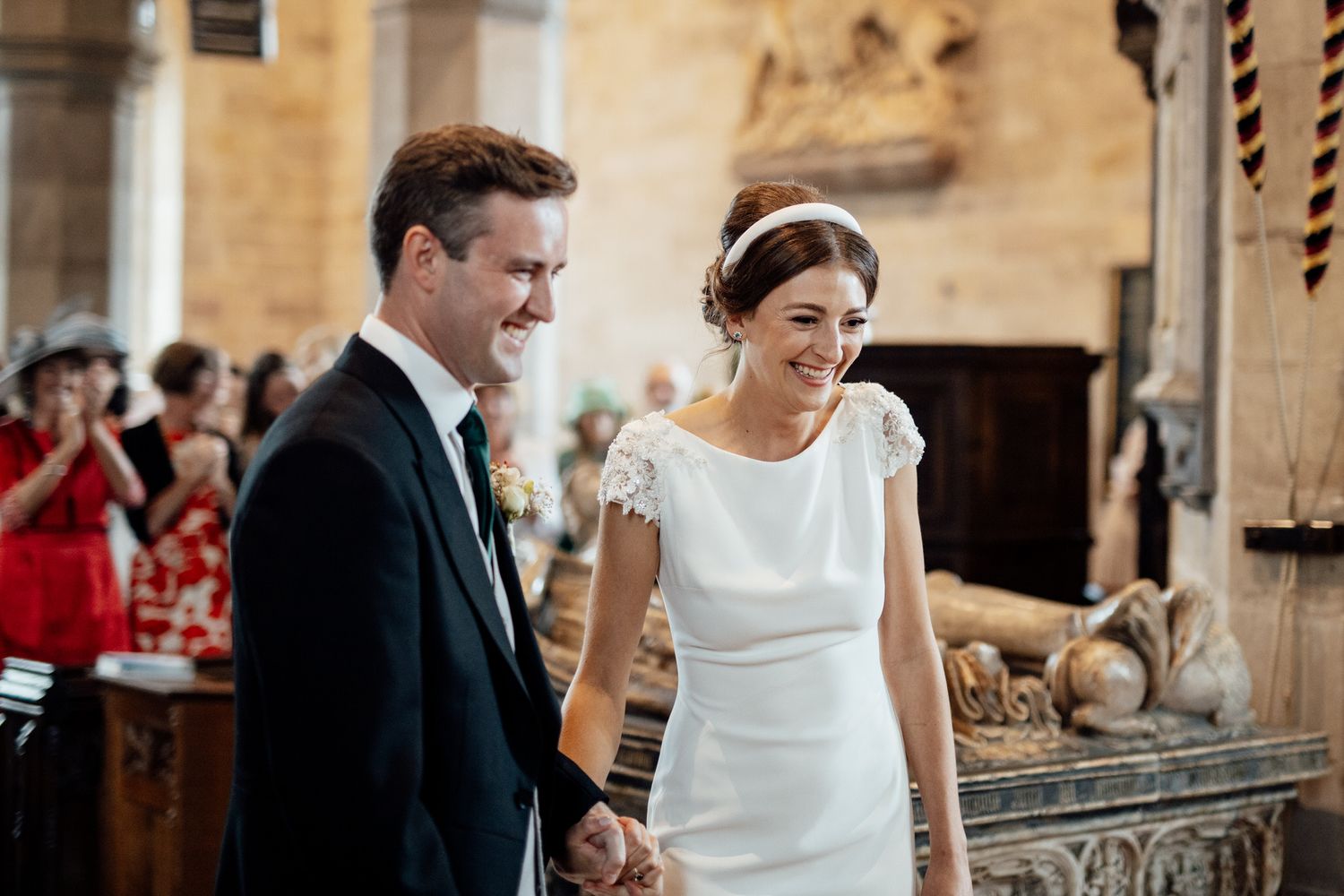 Wedding party gathered in a historic stone church with beautiful natural lighting.