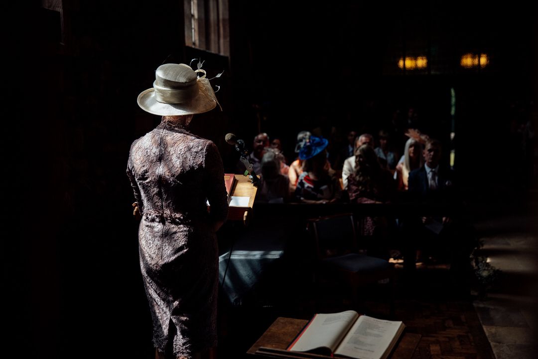 Dimly lit wedding reception with guests gathered at tables.
