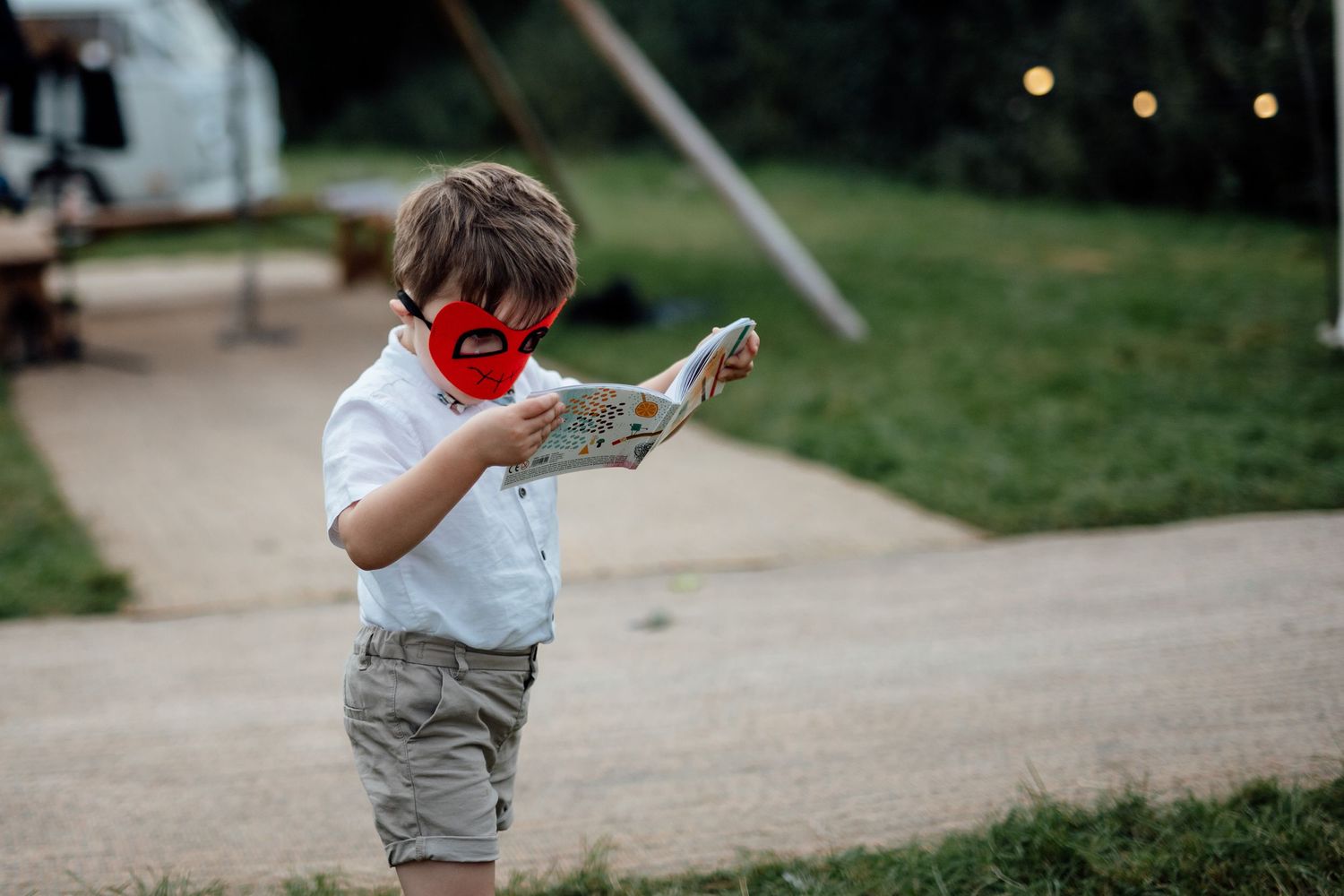 Children playing and running on a grassy path at an outdoor event.
