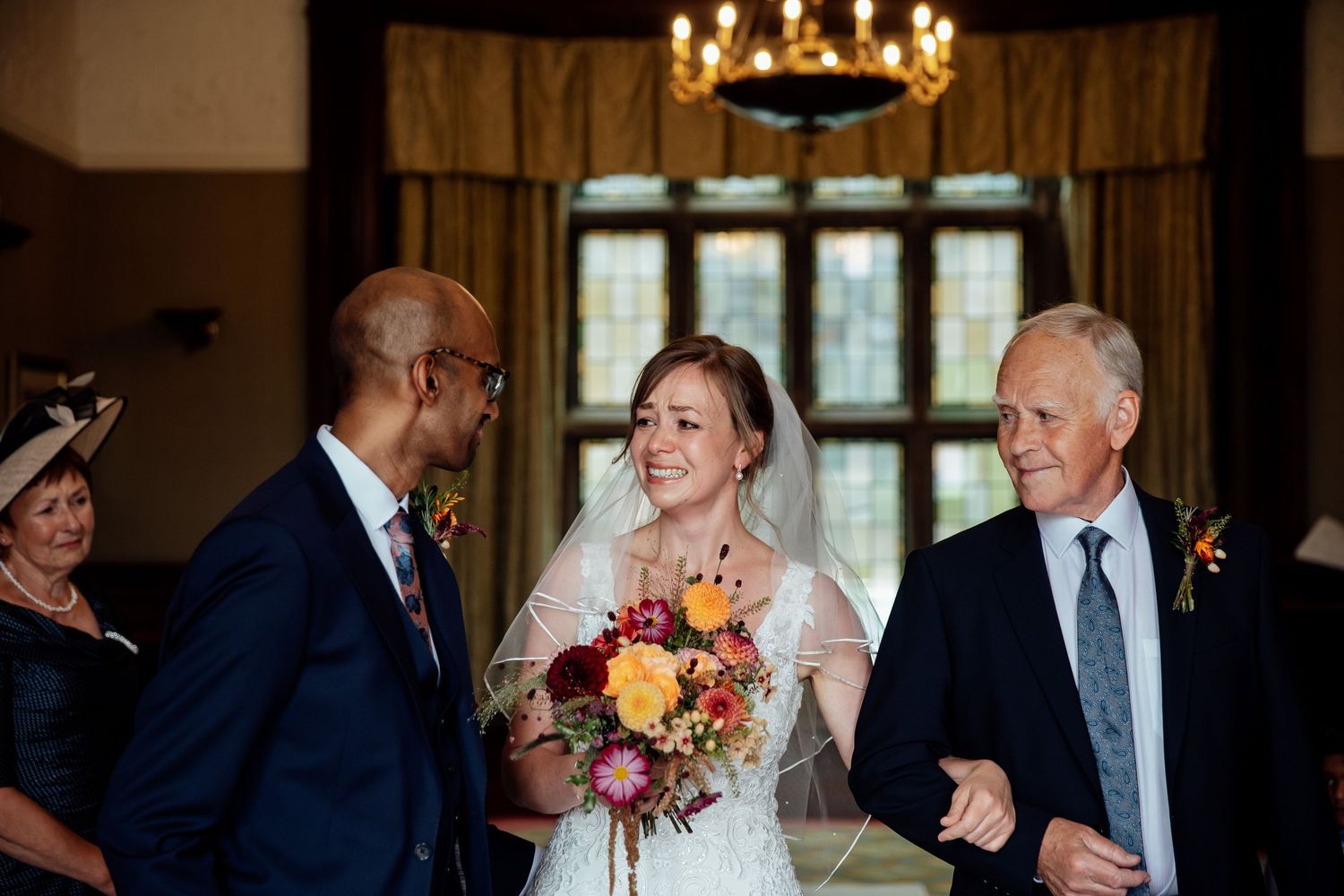 A joyous wedding ceremony moment with the bride holding a vibrant autumn bouquet.