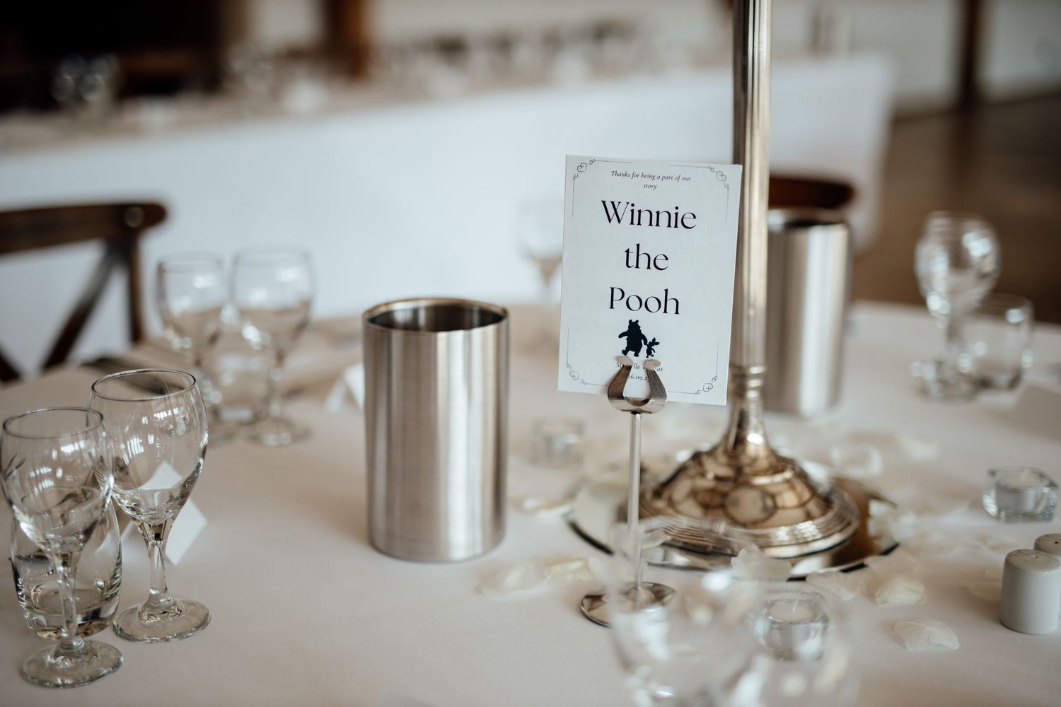 Elegant table settings with wine glasses and place cards at wedding reception.
