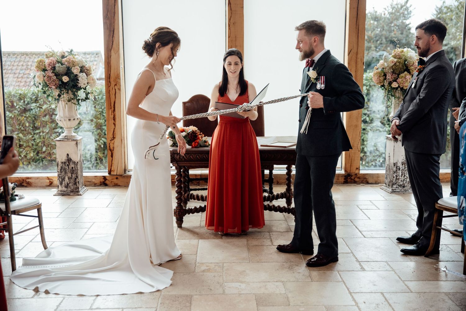 Wedding ceremony moments captured in bright indoor venue with guests in formal attire.