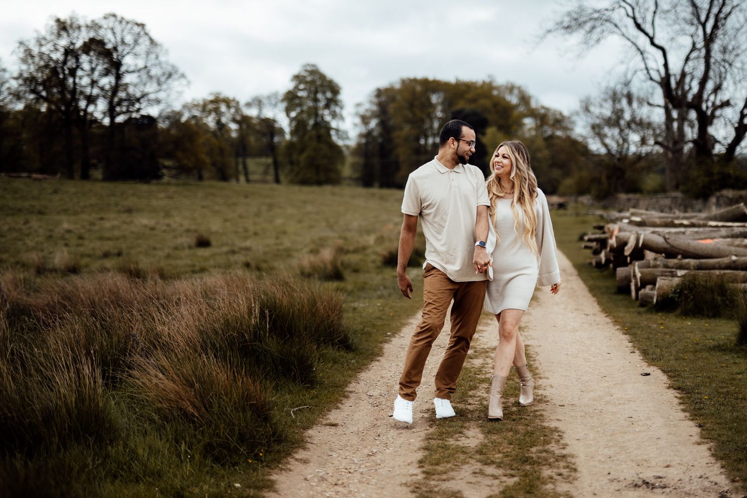 A family walks together on a winding dirt path through a natural landscape.
