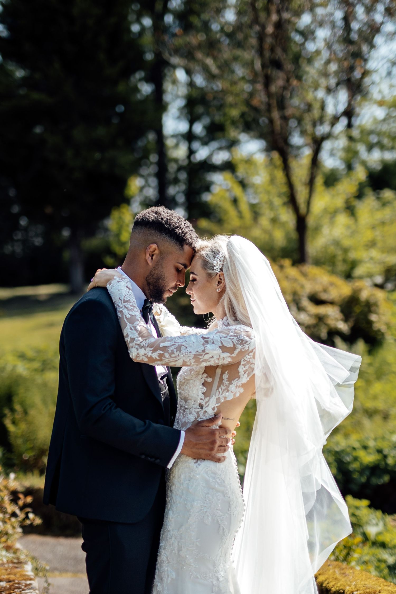 Romantic wedding portraits captured in a sunlit garden setting.