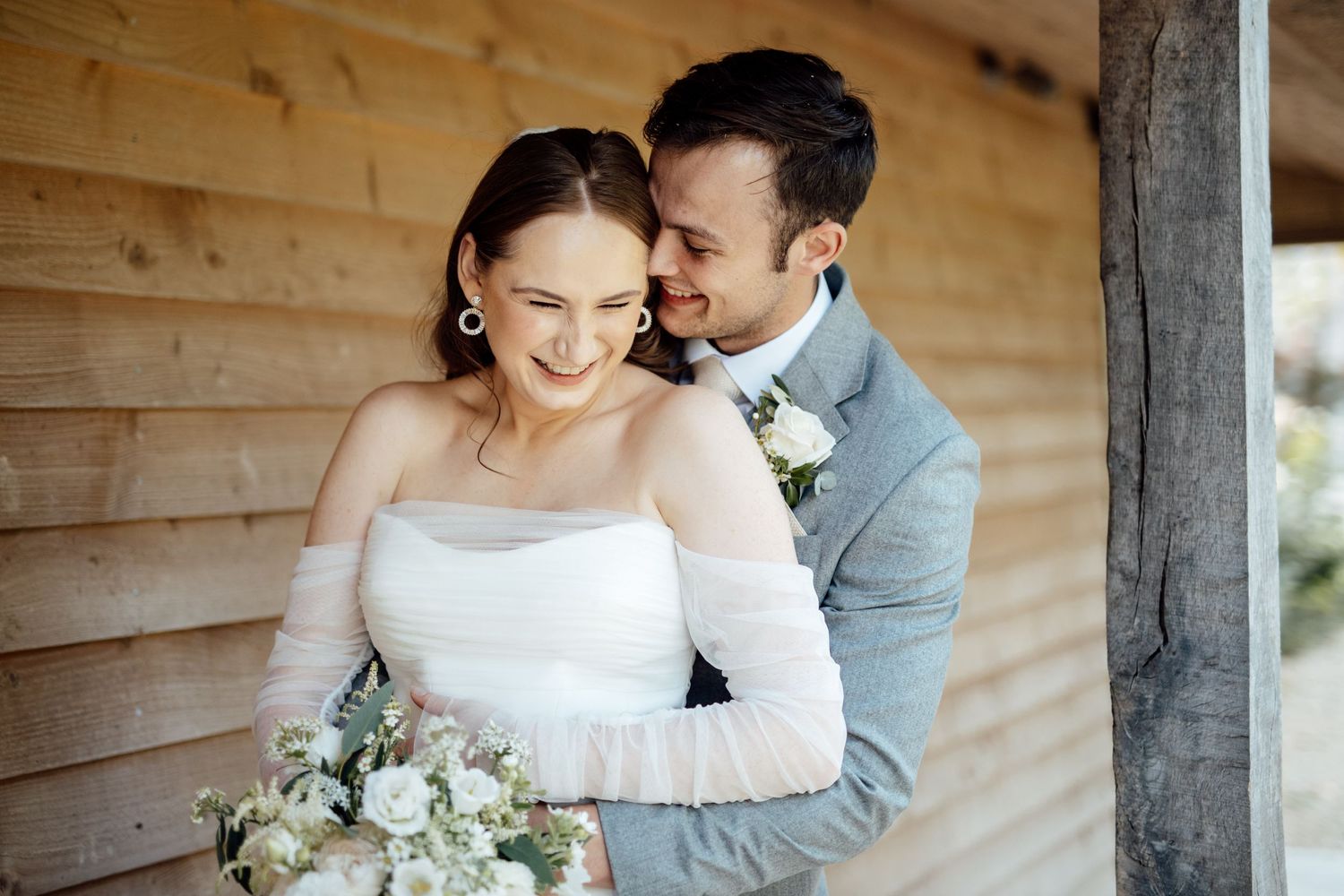 Romantic wedding portraits captured against natural wooden paneling in soft lighting.