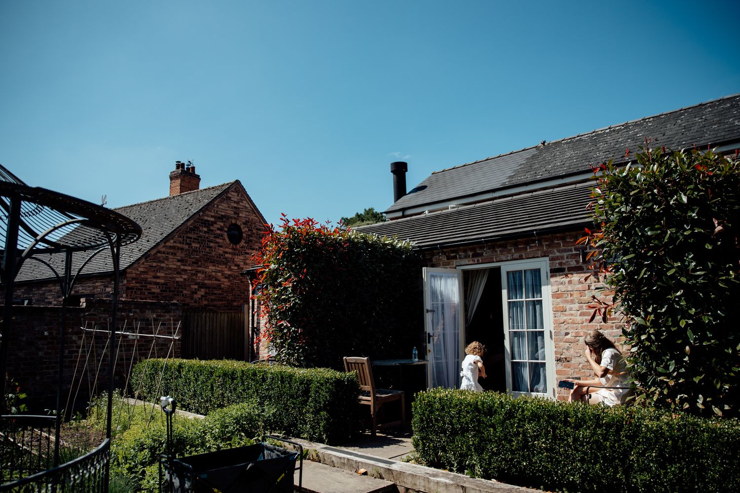 Panoramic view of rustic brick wedding venue exterior with blue sky.
