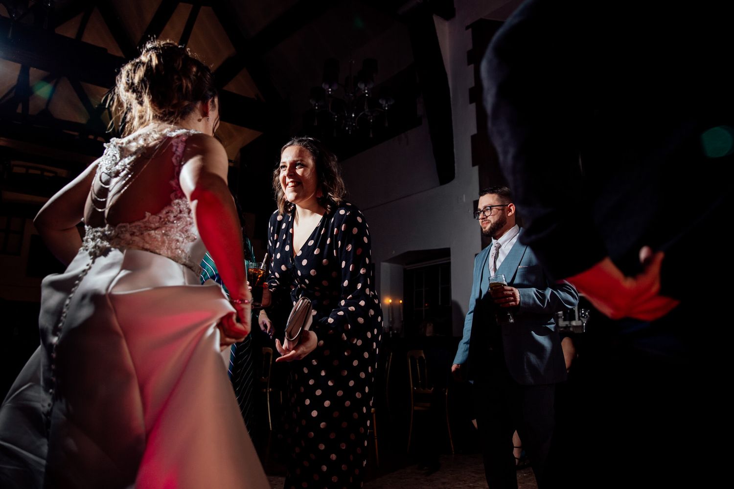 Wedding reception dance floor with dramatic lighting and dancing silhouettes.