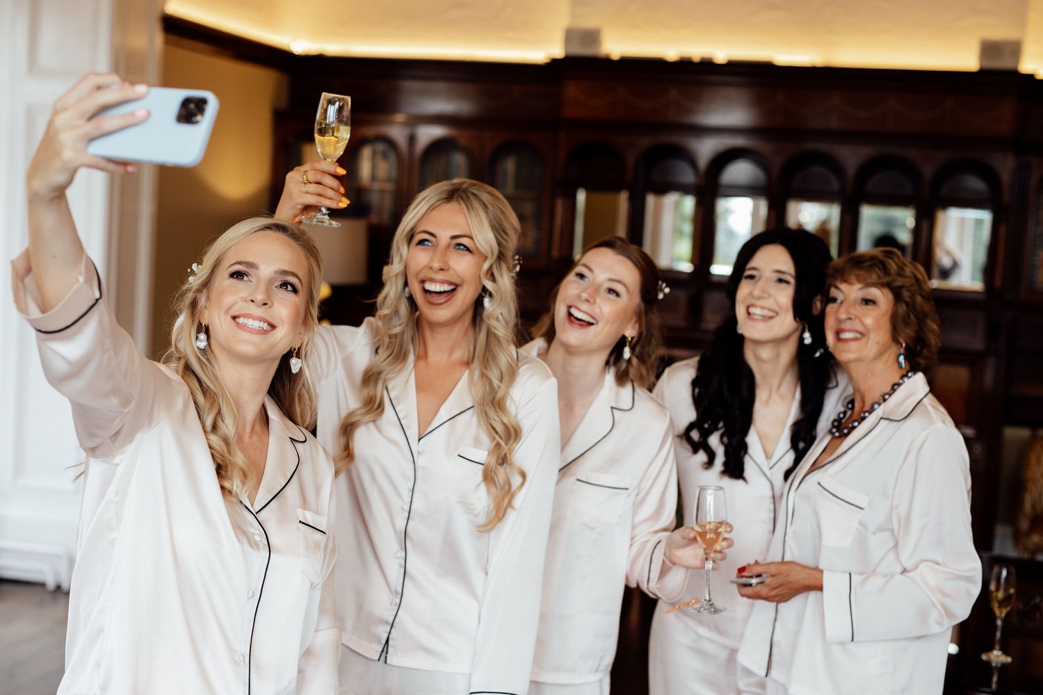 Friends in matching white robes celebrating together in a luxurious venue.