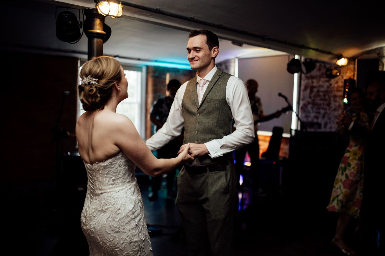 Couples dancing together at a dimly lit wedding reception venue.