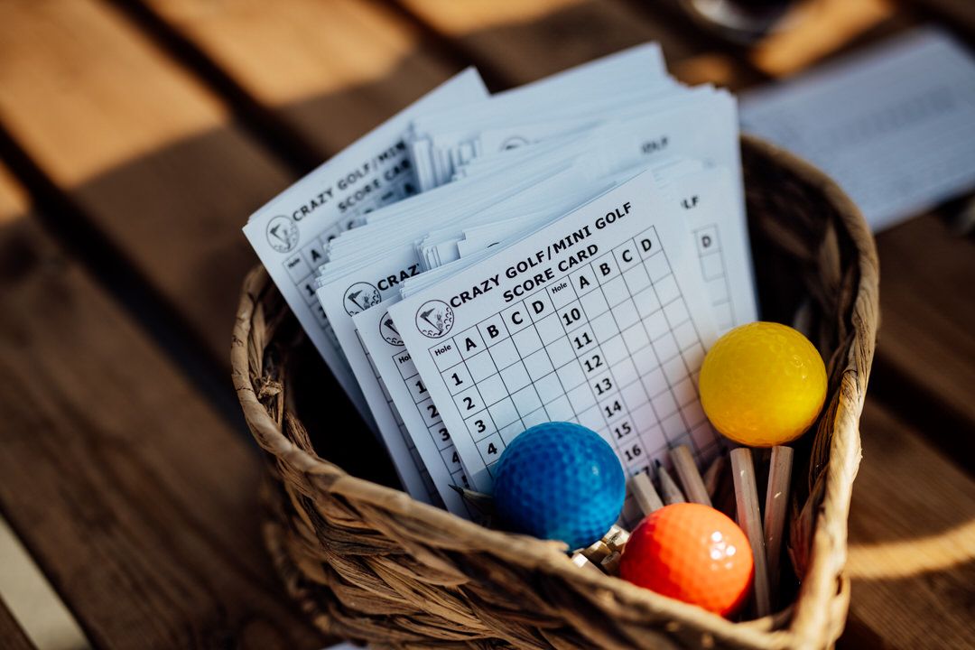 Wedding details including paper cards and colorful decorative balls on dark wooden surface.