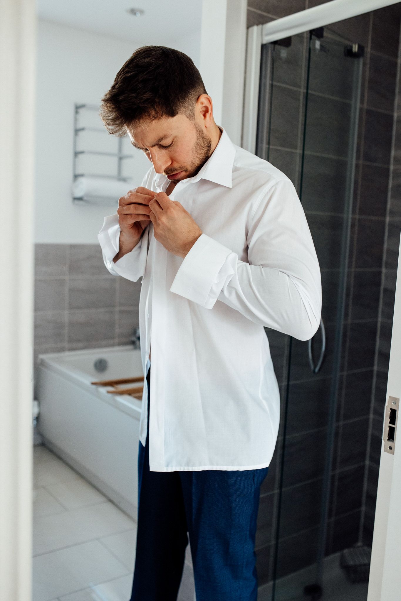 Emotional moment captured in a modern white interior space with dramatic lighting.
