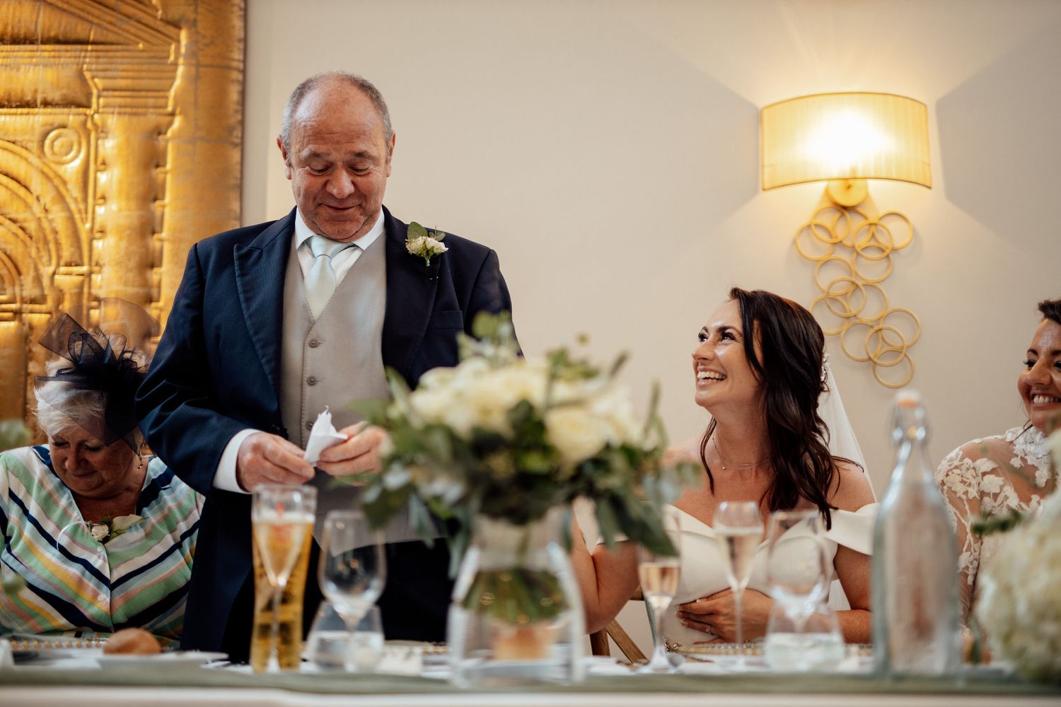 Elegant wedding reception table settings with ambient lighting and floral centerpieces.
