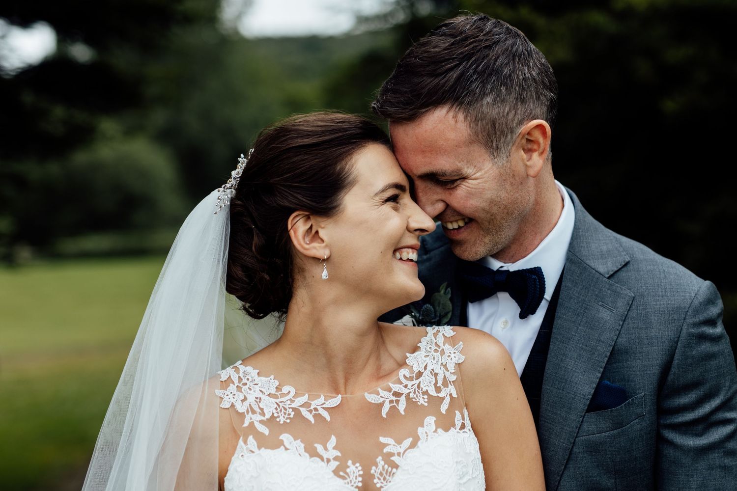 Intimate wedding portrait captured in a lush outdoor garden setting.