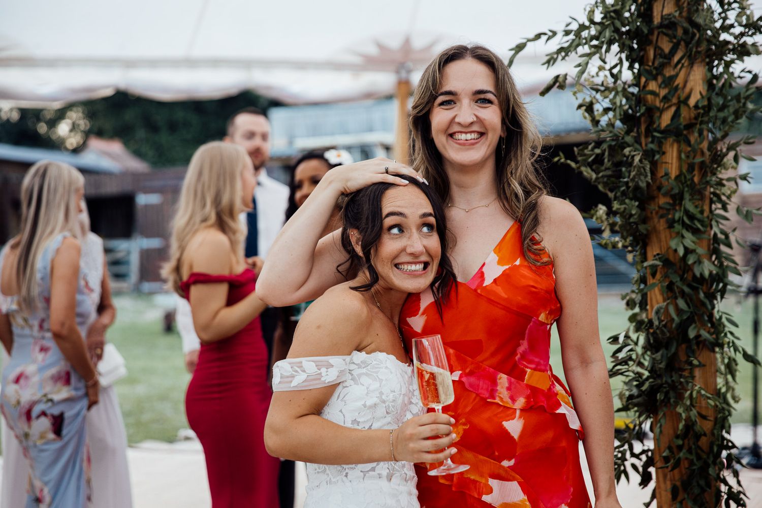 Wedding celebration outdoors with guests in formal attire enjoying champagne.