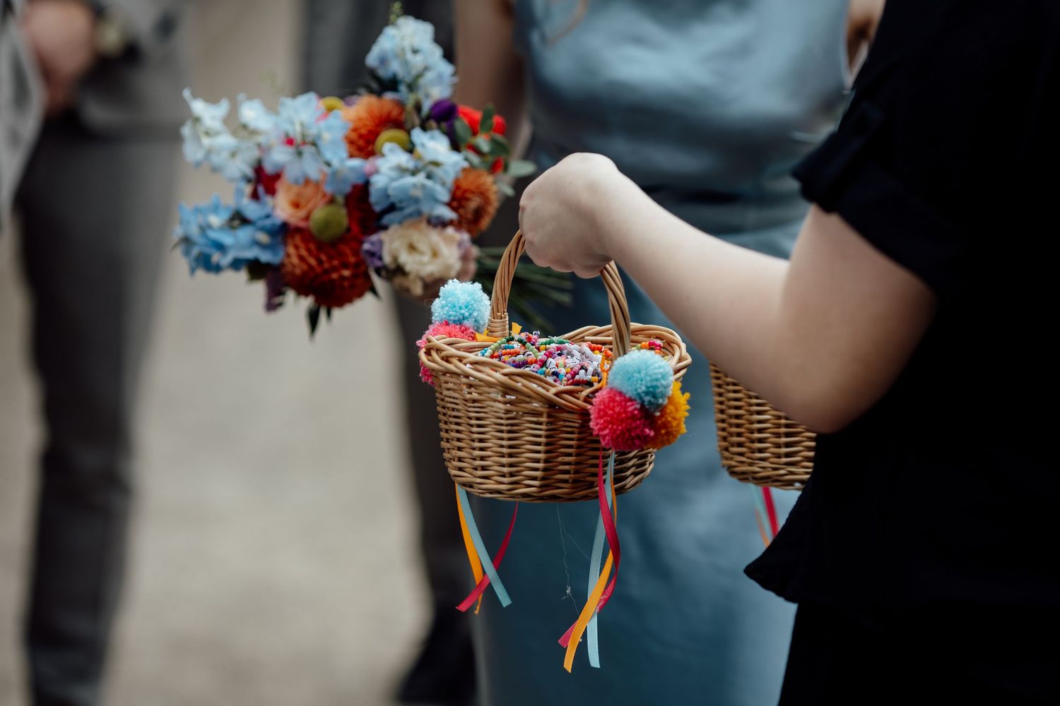Wedding party members holding floral bouquets with blue and orange accents.