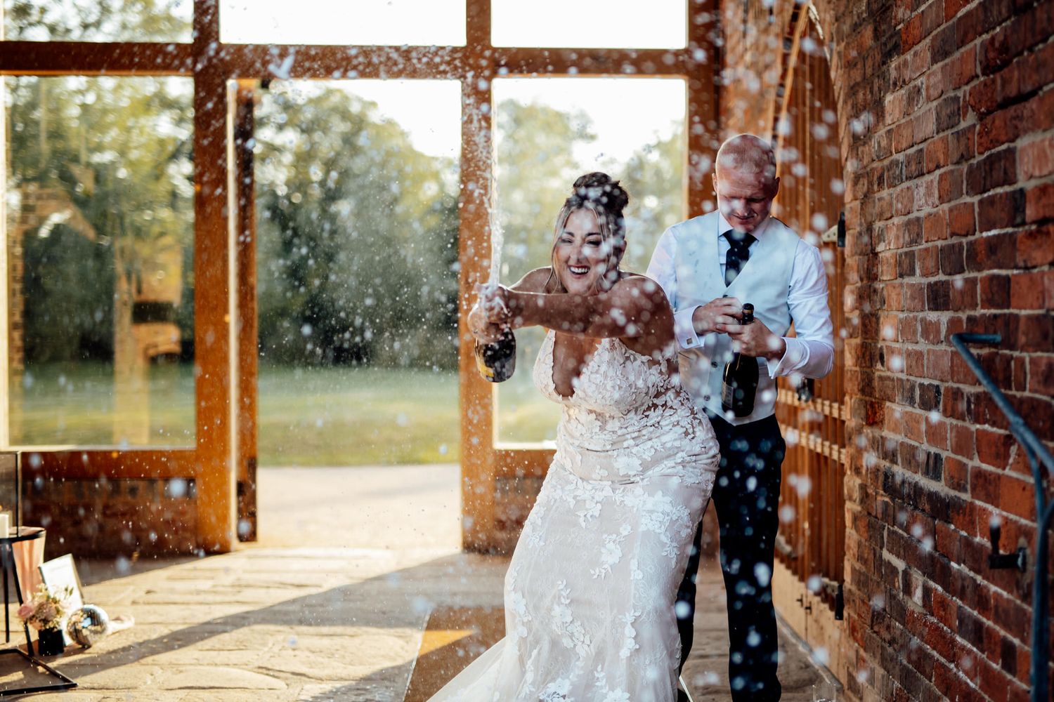 Wedding ceremony setup in a rustic brick venue with natural lighting streaming through windows.