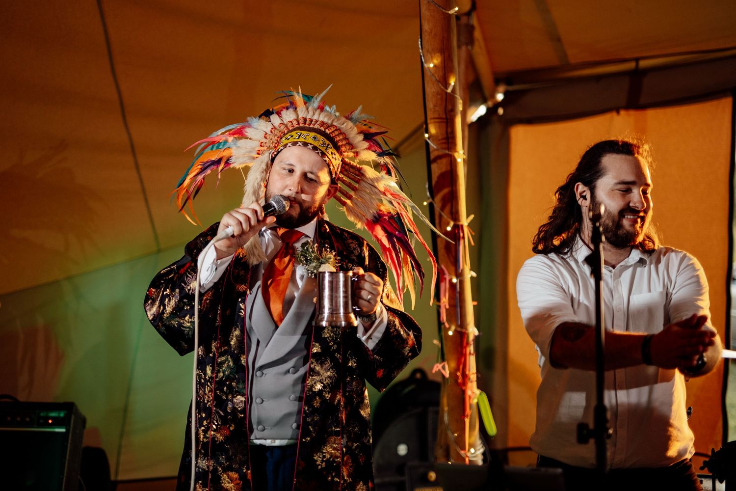 Energetic wedding band performance with singer in patterned jacket on stage.