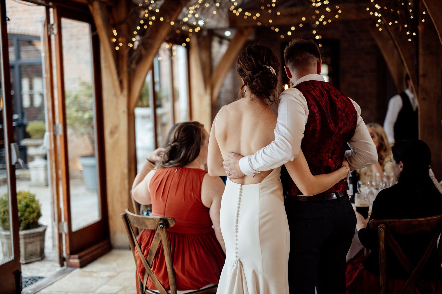 Wedding celebration in a rustic barn venue with burgundy and white decor details.