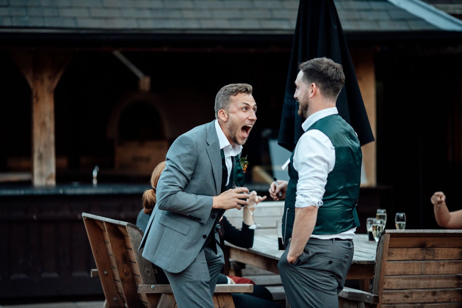 Guests enjoying drinks and conversation in a rustic indoor venue.
