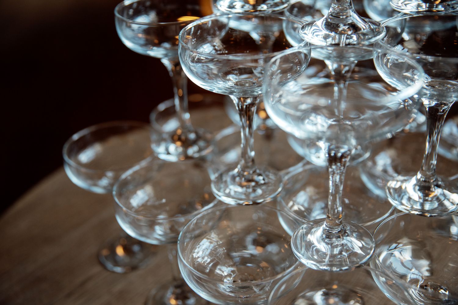 Close-up of elegant crystal champagne glasses arranged on dark surface.