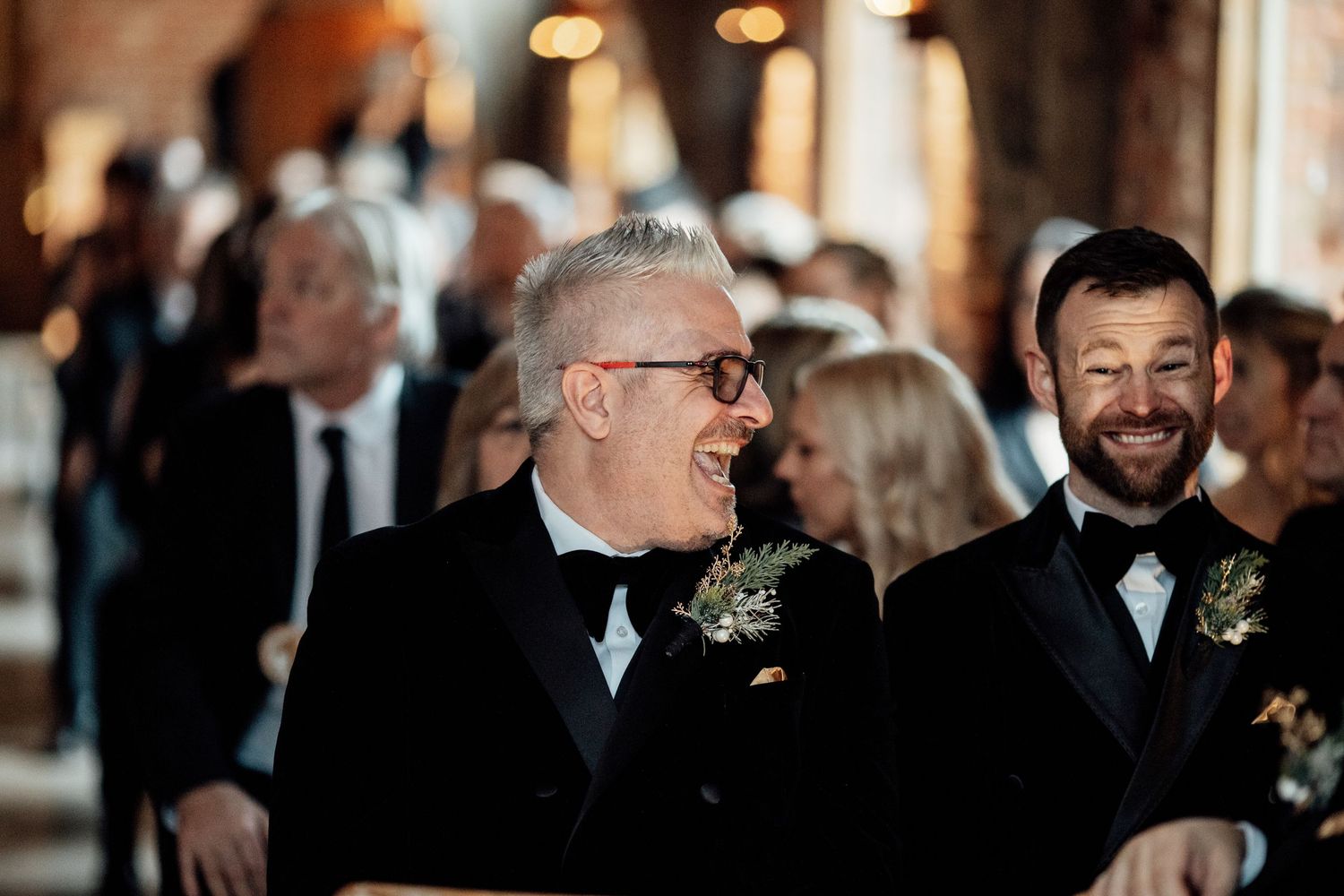 Wedding guests in formal attire share a joyful moment during the celebration.