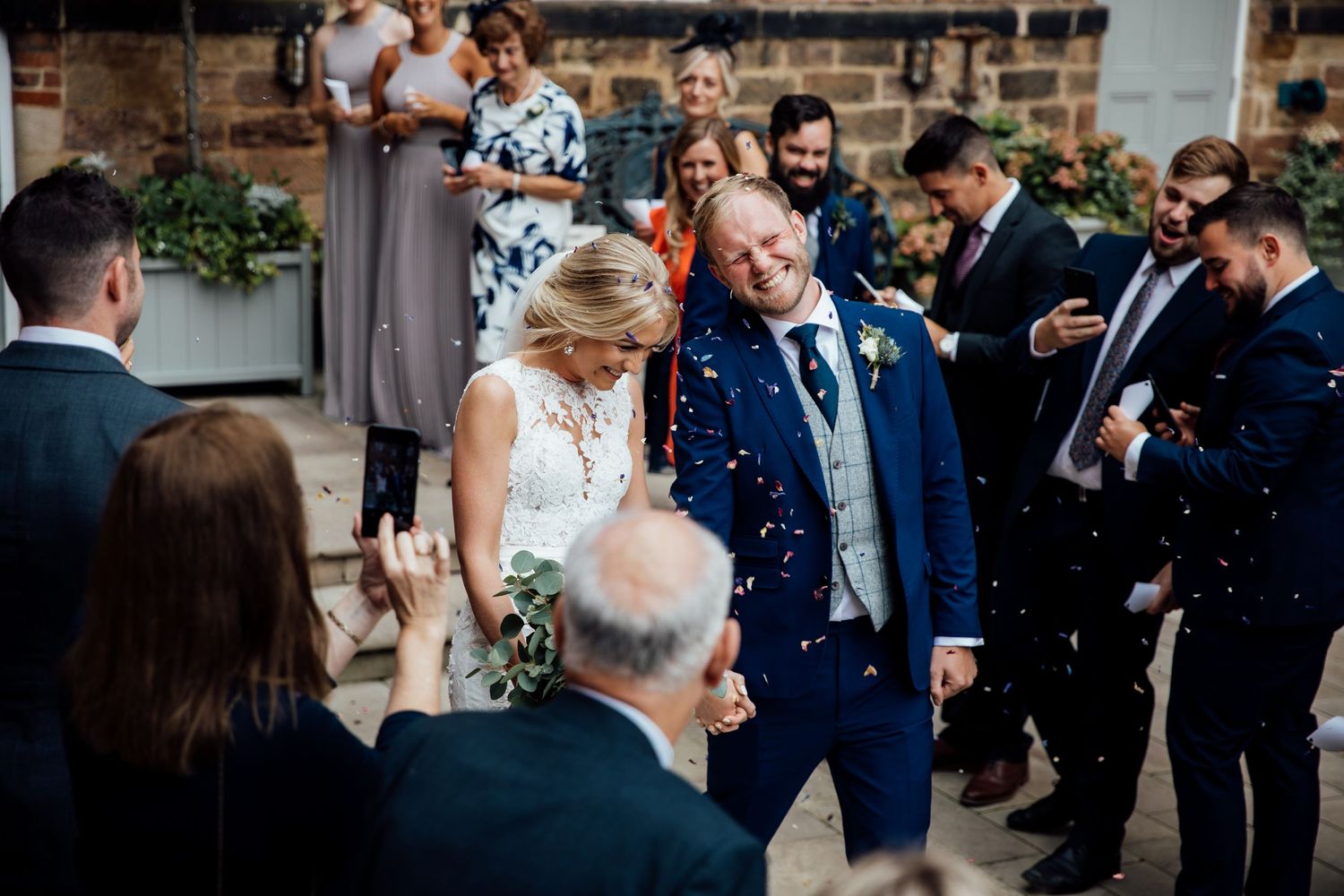 Wedding celebration with guests mingling in an industrial-style brick venue.