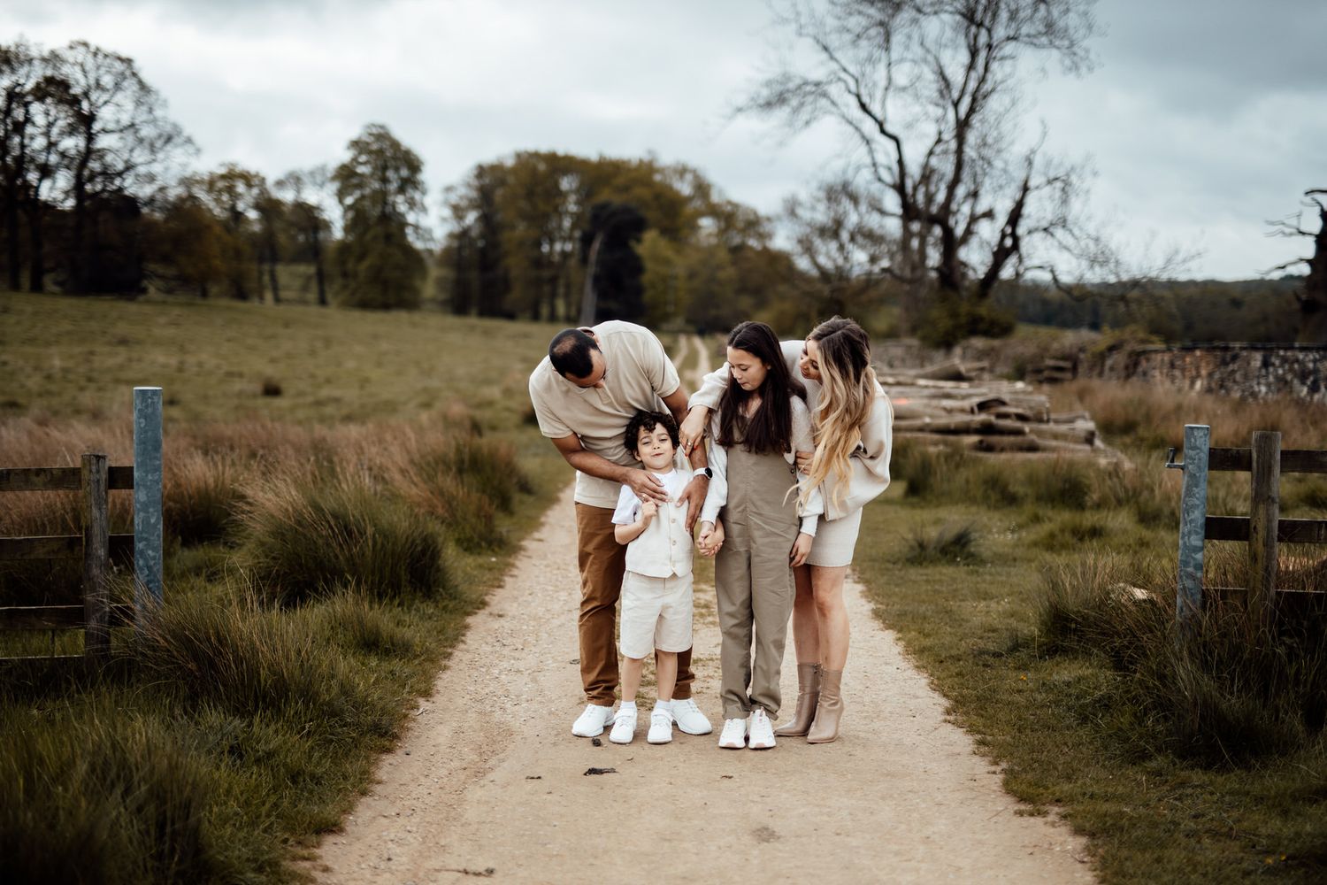 Family walking together on a winding dirt path through natural grassland.