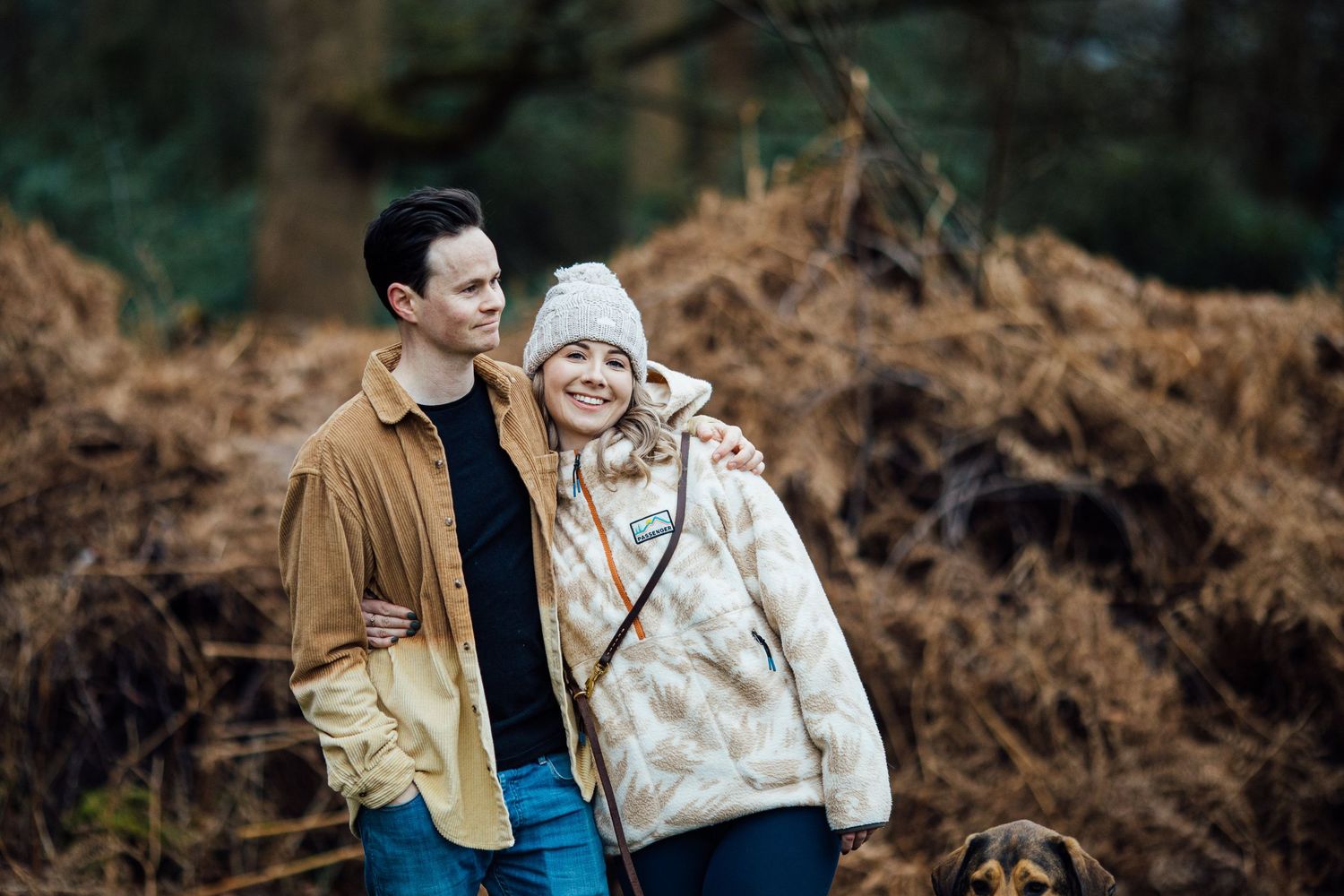 A couple enjoying a walk together in autumn woodland scenery.