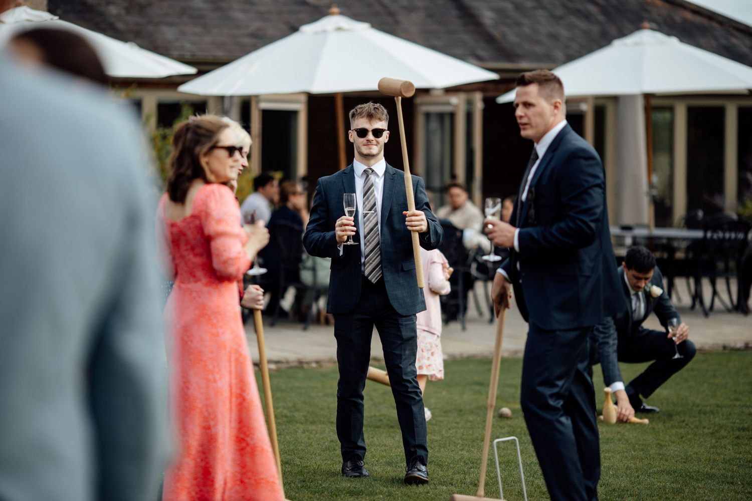 Wedding guests playing lawn games during outdoor reception.