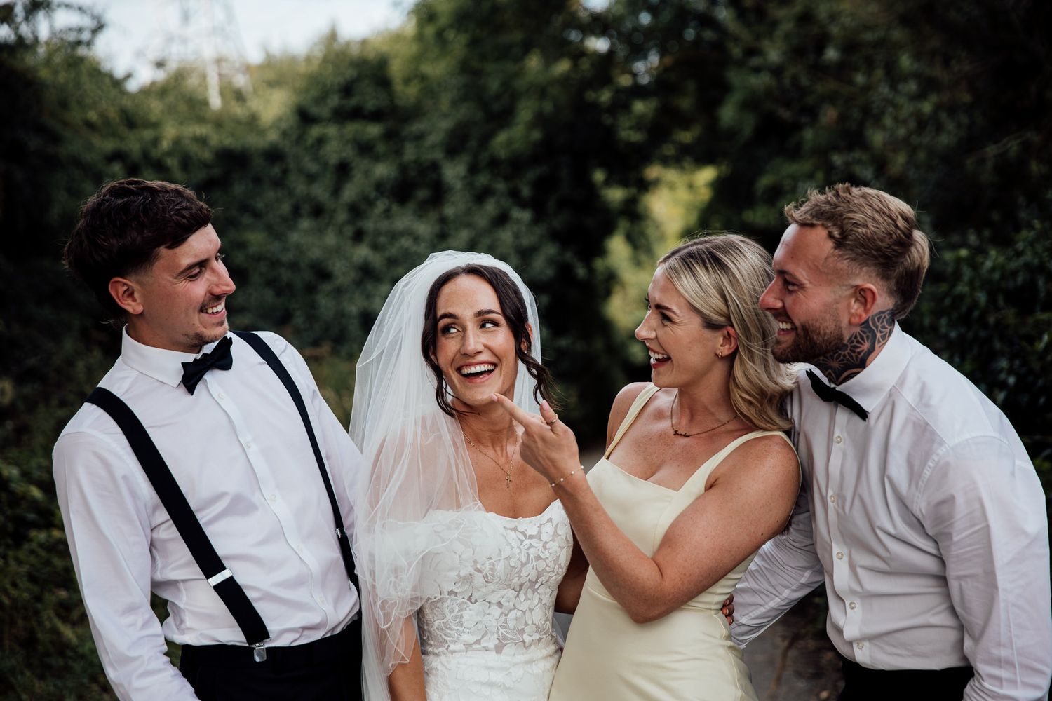Wedding party members share joyful moments outdoors during golden hour.