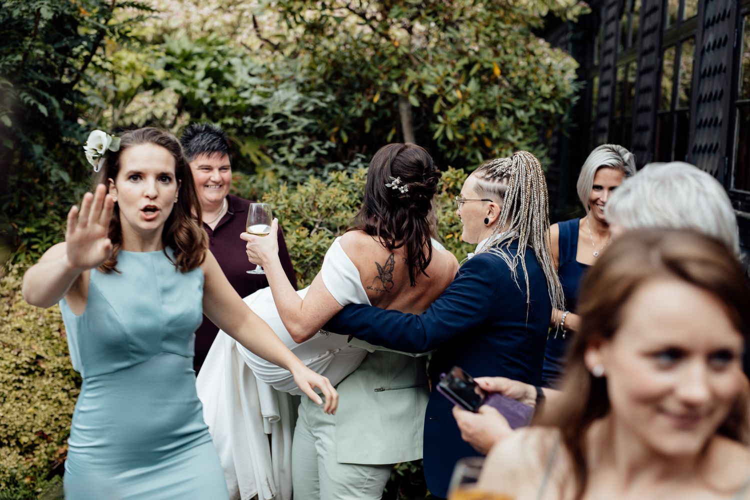 Outdoor wedding celebration with guests in blue and mint colored attire.