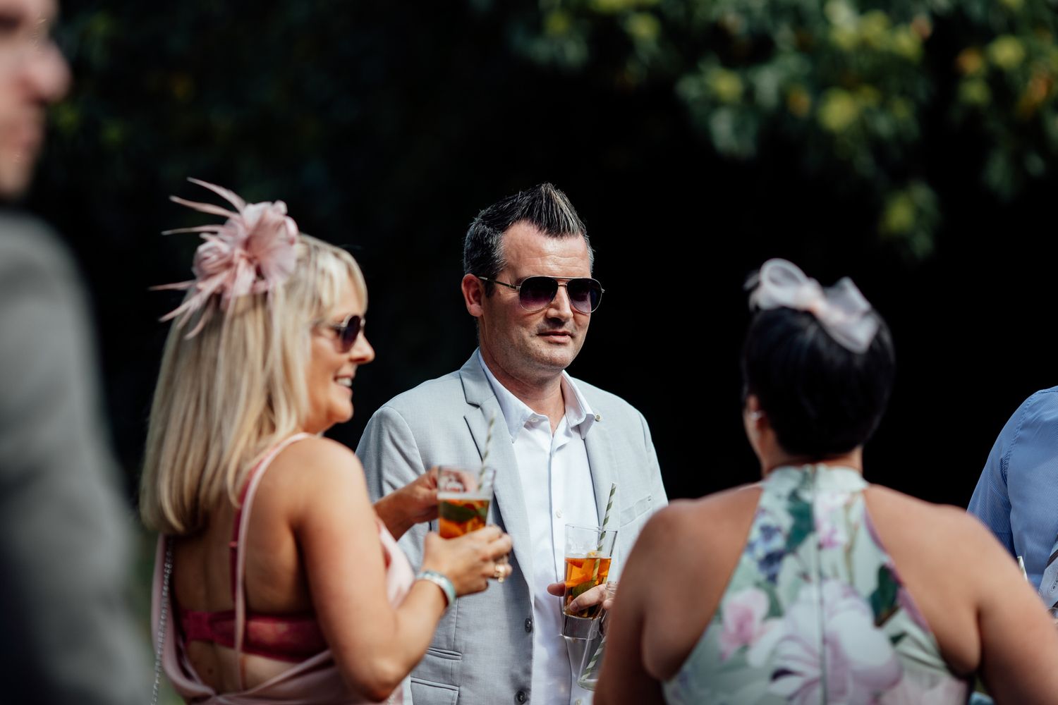 Wedding guests enjoying drinks and conversation at an outdoor reception.