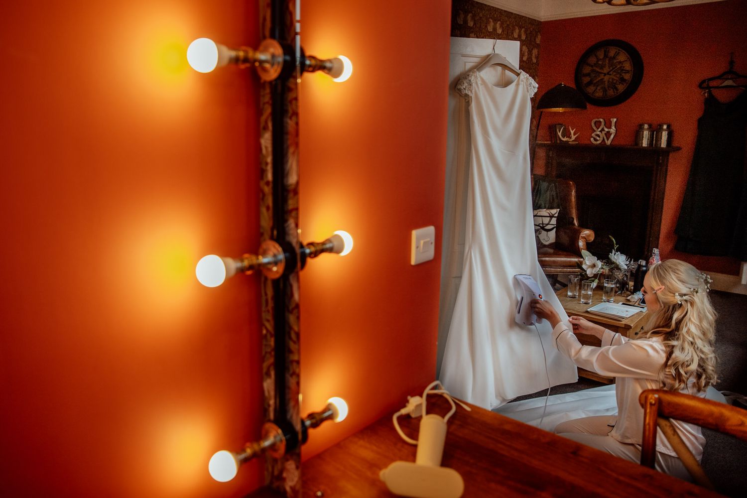 A white dress hanging in a warmly lit room with wooden details.