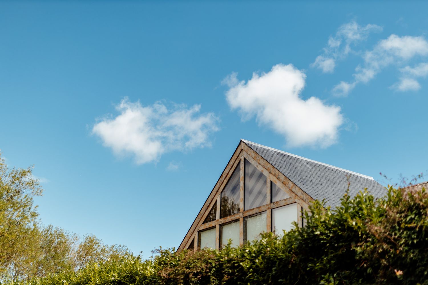 Exterior view of a wedding venue with blue sky and white clouds on a sunny day.