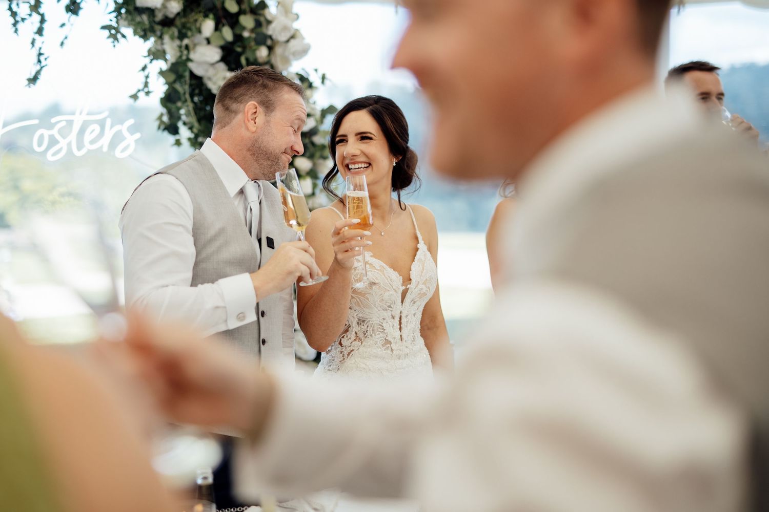 A celebratory moment during an outdoor wedding reception with champagne glasses.