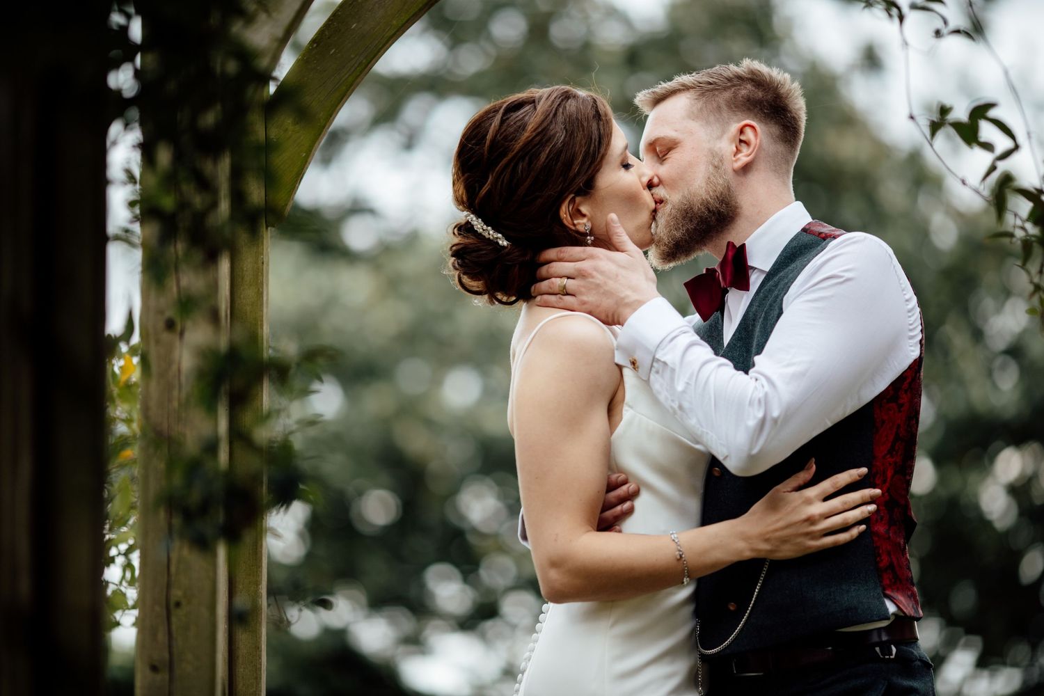 Intimate wedding couple portraits taken in a romantic garden setting with bokeh lighting.