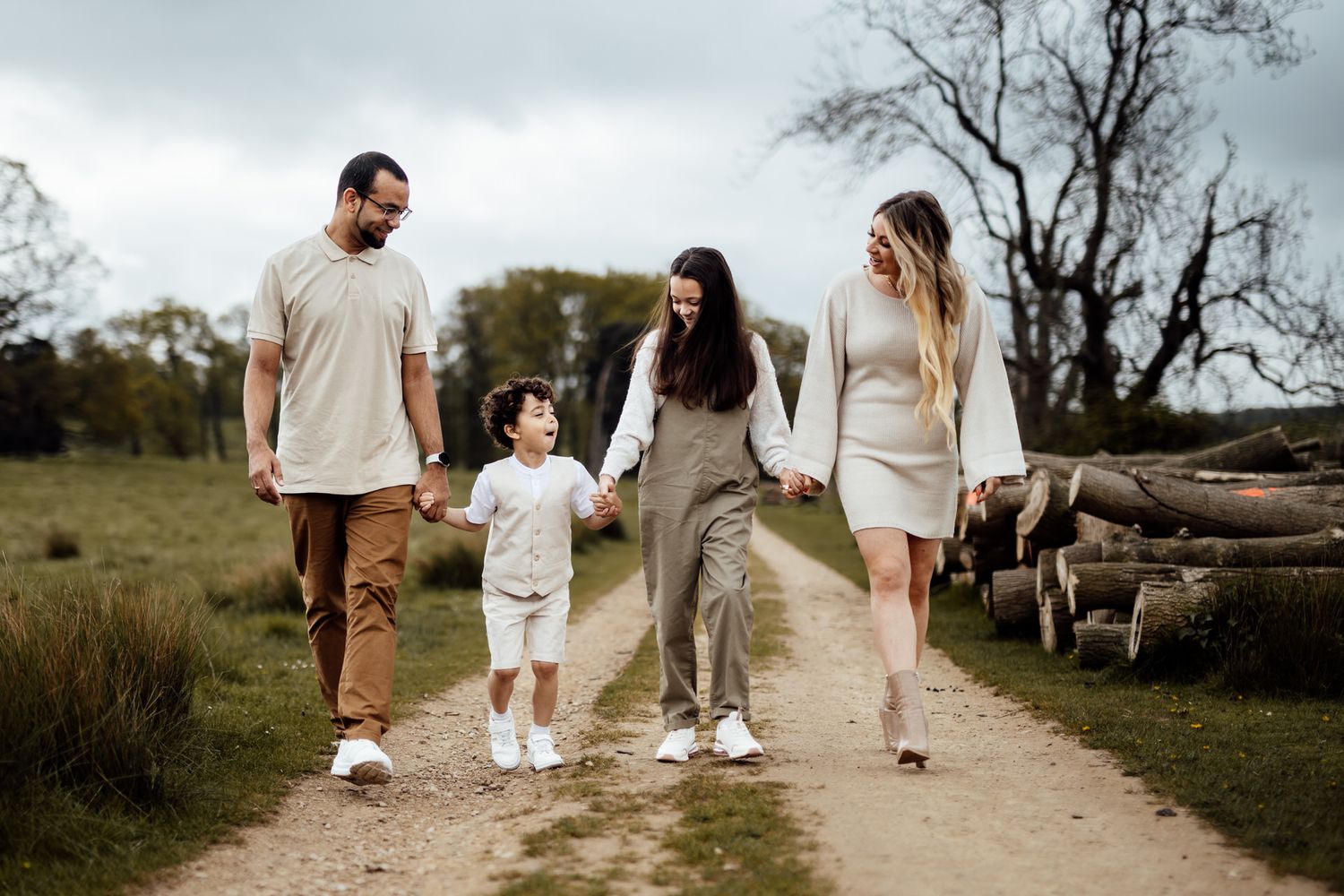 Family walking hand in hand down a winding country path at dusk.