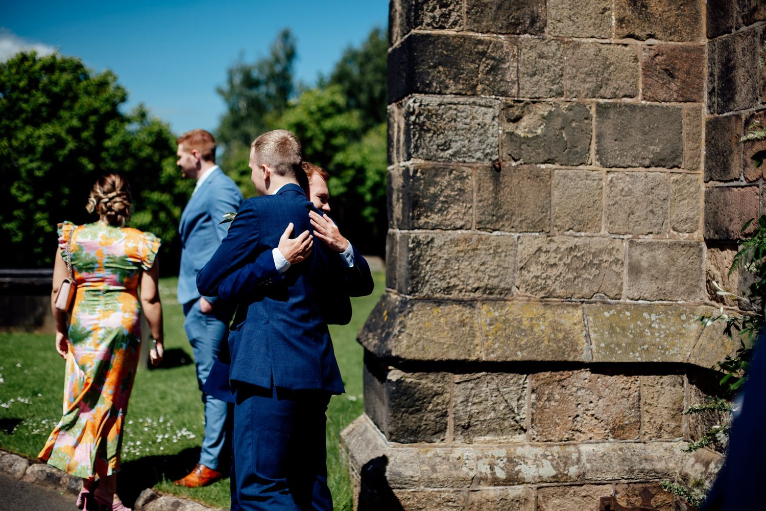 Stone church exterior with beautiful landscaping on a sunny wedding day.