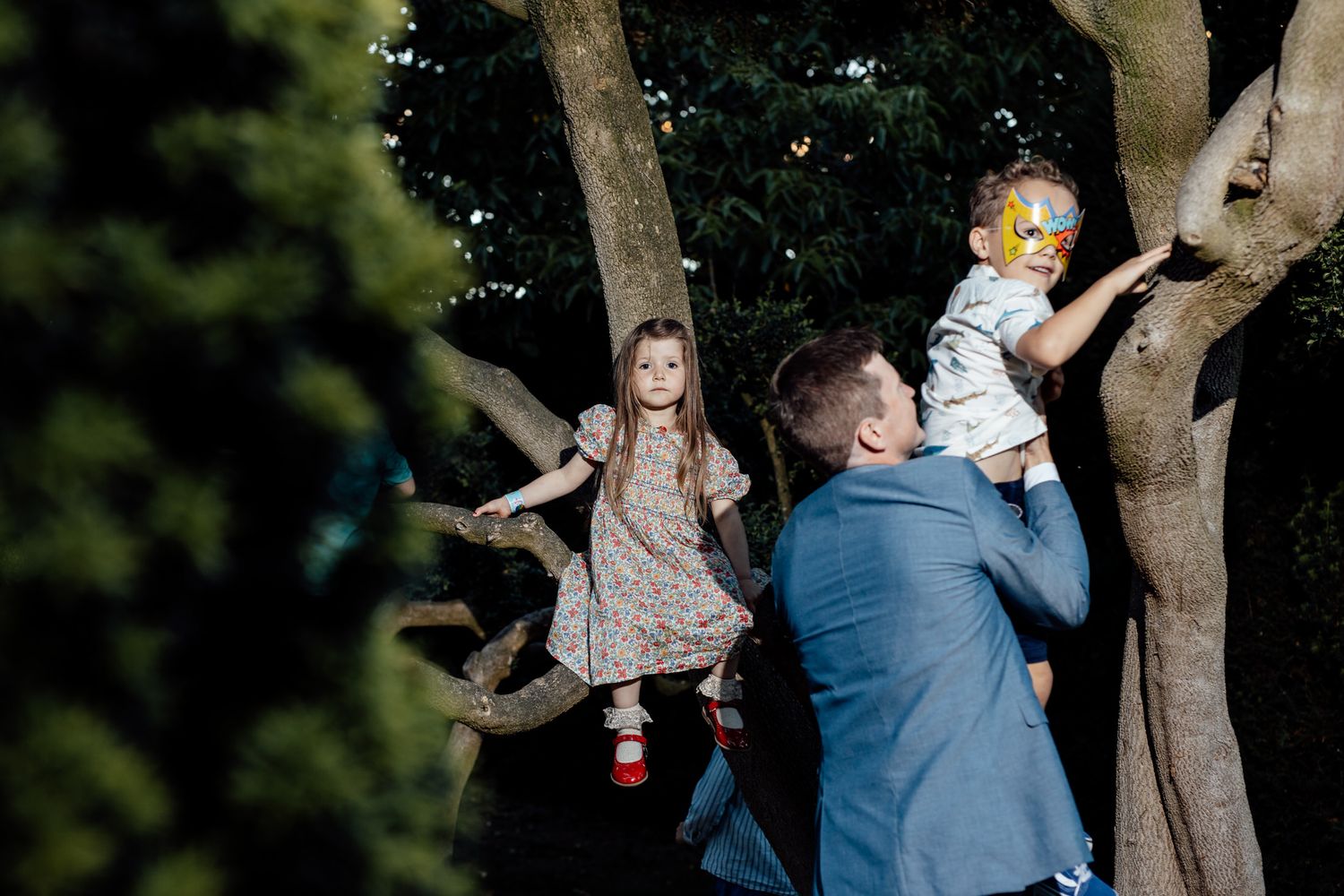 Wedding party enjoying candid moments outdoors among trees.