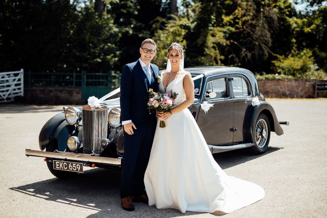 Classic vintage car parked outside during wedding celebration.