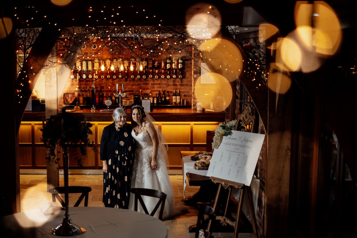 Evening wedding reception venue with warm ambient lighting and bokeh effects.