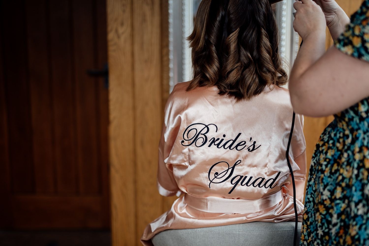 Silk robes with 'Squad' lettering worn during wedding preparations.