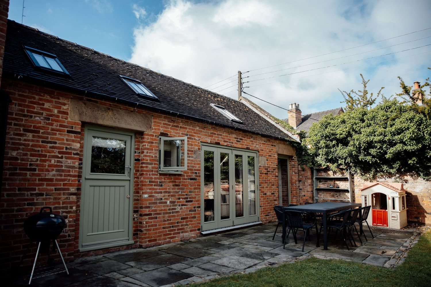 Exterior view of a converted brick barn wedding venue with blue sky.
