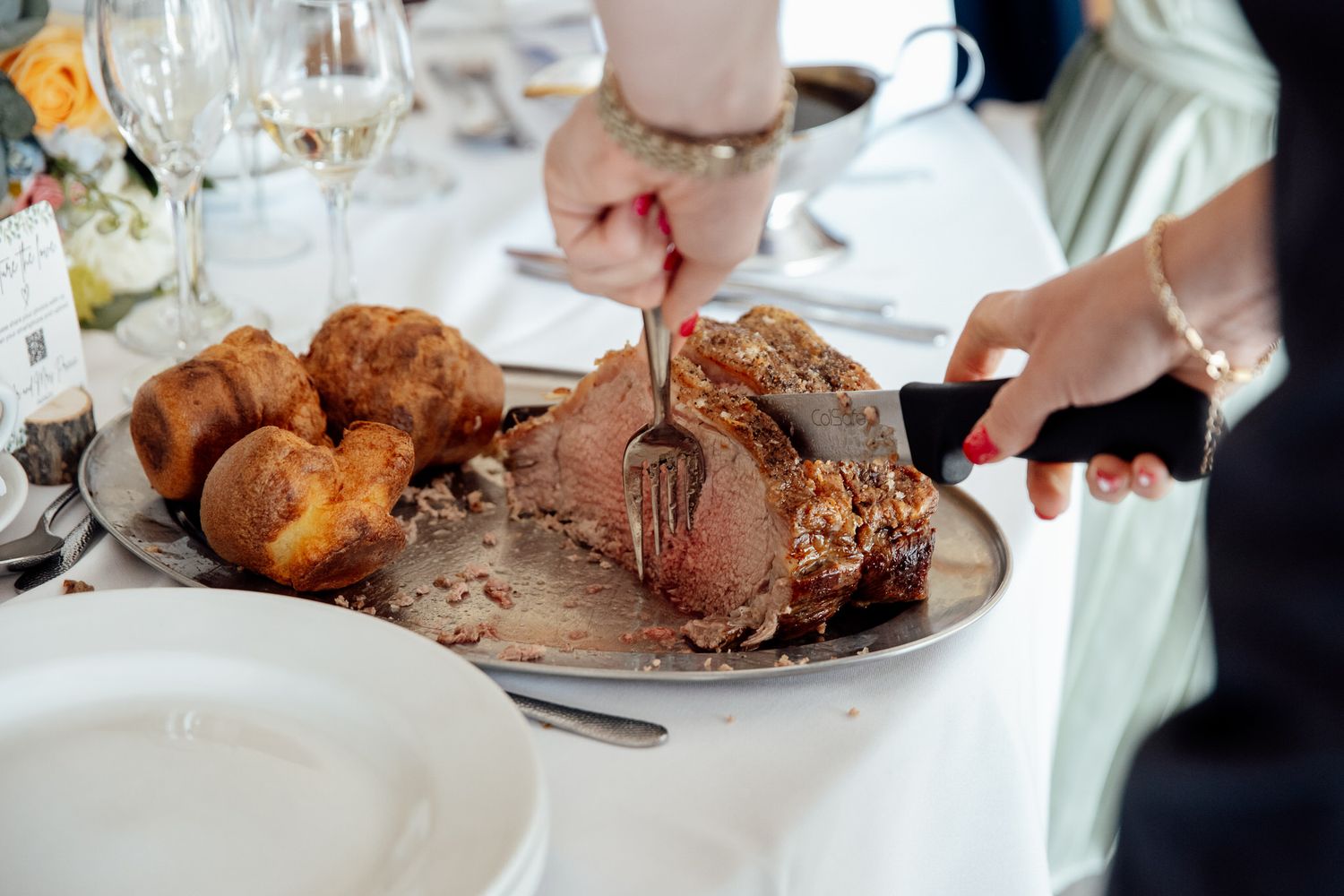 Wedding reception dinner plates with roasted meats and side dishes.