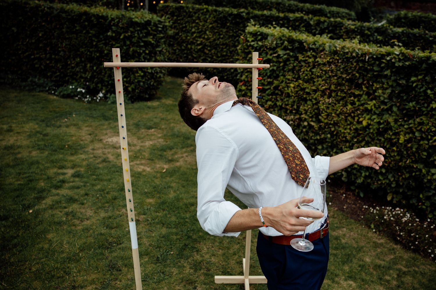 Wooden cross ceremony arch setup in garden lawn setting.